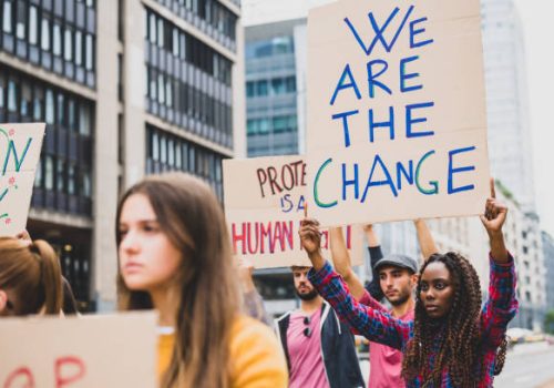 people strike against climate change and pollution, young african woman holding a poster communicating we are the change